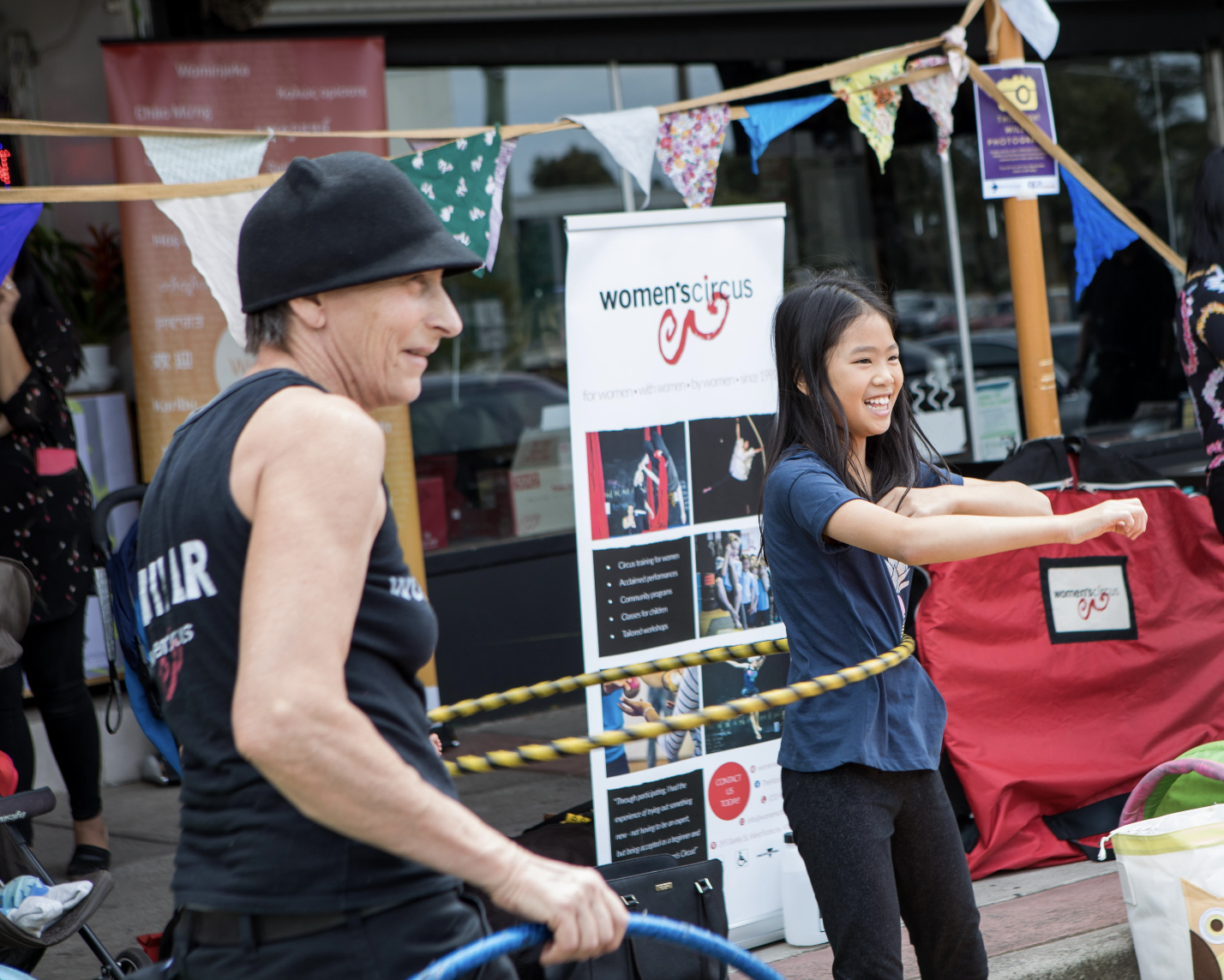 Women's Circus trainer Franca with young person hula hooping at a festival drop in station workshop