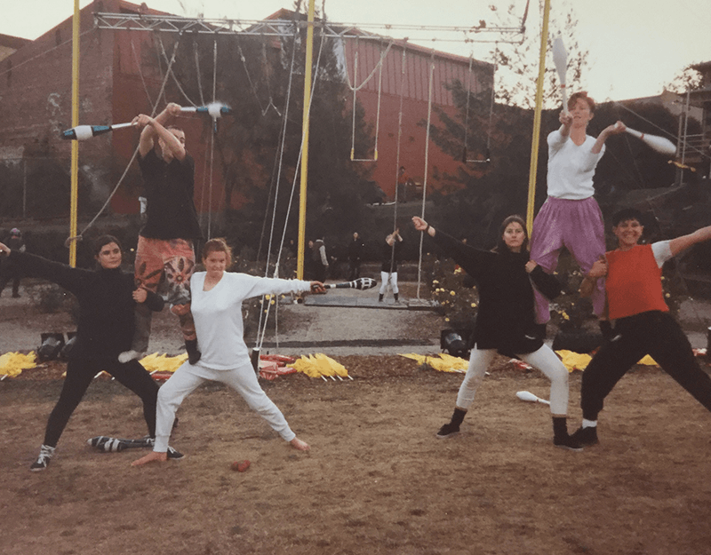 A group of people performing circus tricks outdoors.