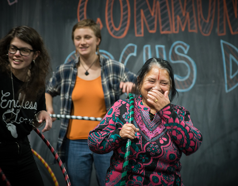 Three laughing women playing with hula hoops.