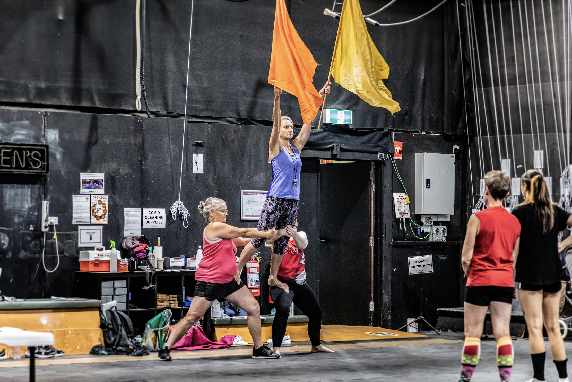 Women's Circus members doing acro with flags for Flying Shot development 